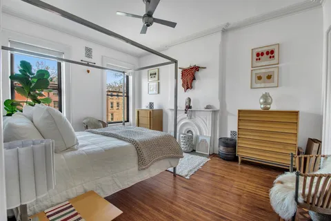 a bedroom with a bed and wooden floor