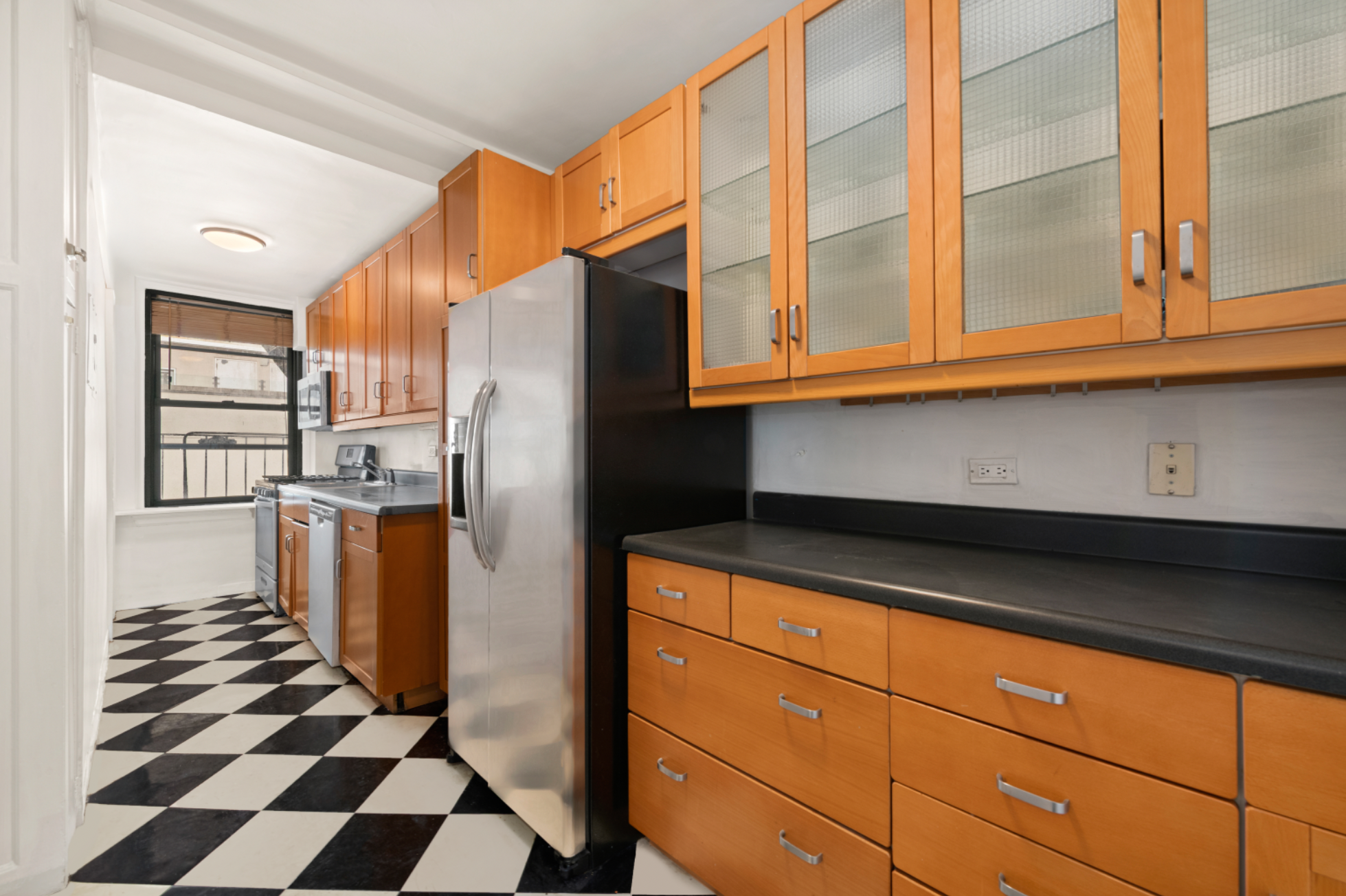 210 East 73rd Street, Unit 9EF Manhattan, NY 10021 - Photo 6 of 16 a kitchen with a refrigerator a microwave and cabinets