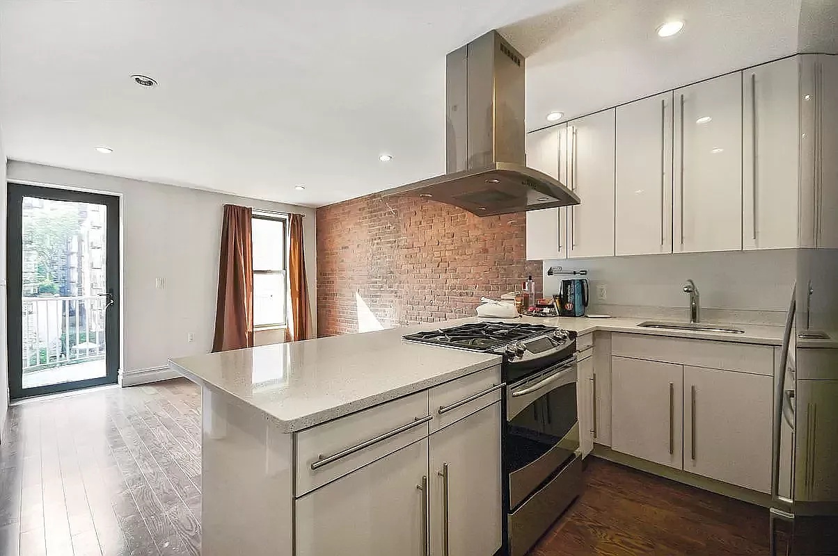 1569 2nd Avenue, Unit 301 Manhattan, NY 10028 - Photo 2 of 9 a kitchen with a stove a sink and a refrigerator