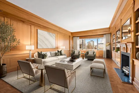 a living room with fireplace furniture and a large window