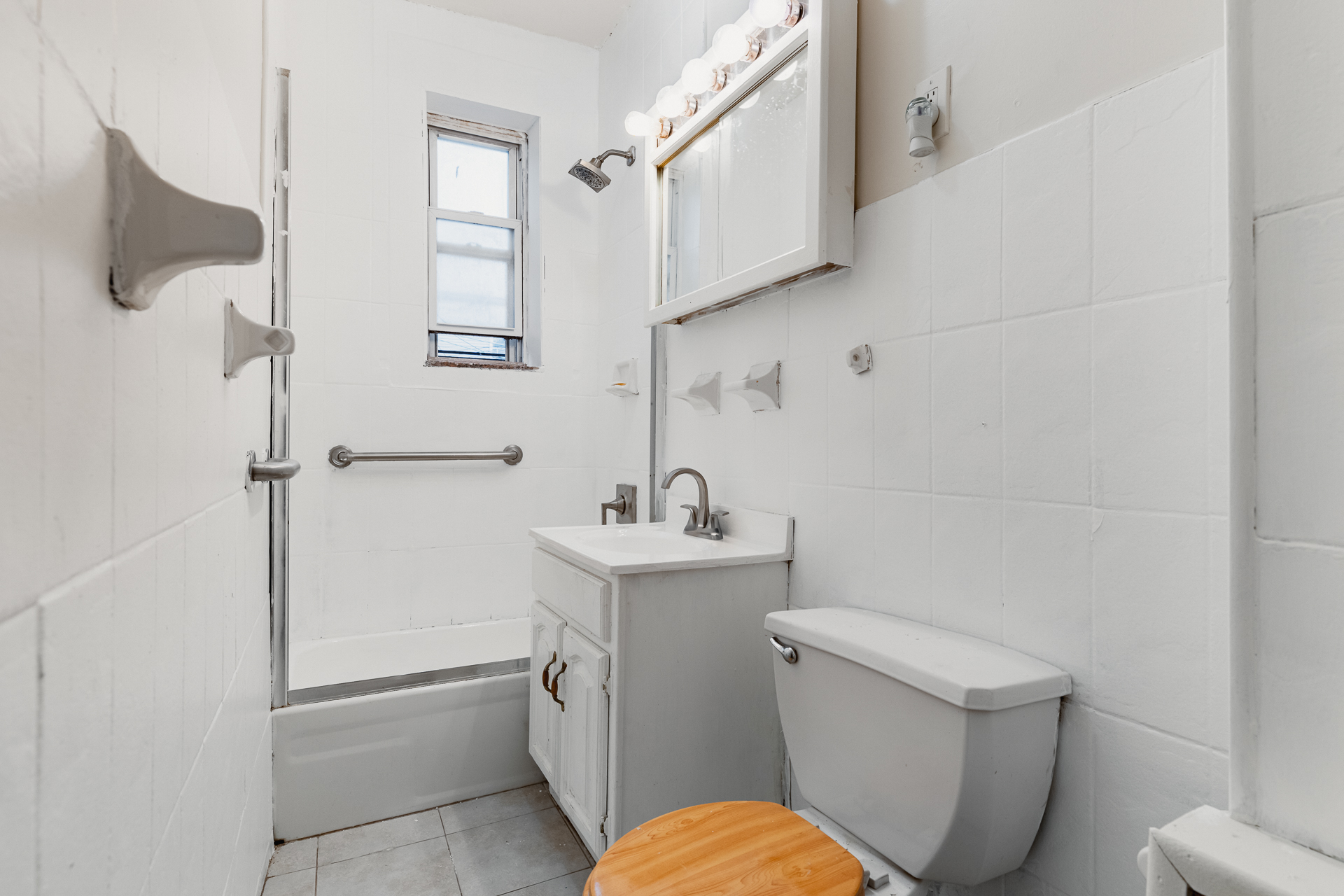 70-03 66th Street, Unit 1L Queens, NY 11385 - Photo 8 of 8 a bathroom with a toilet sink and mirror