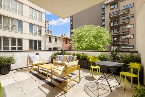a view of a patio with couple of chairs and potted plants