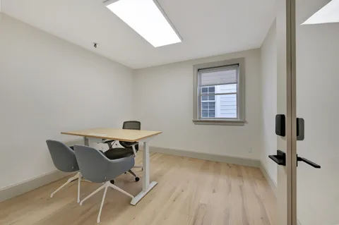 a view of a workspace with wooden floor and a window