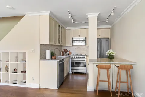 a kitchen with granite countertop a stove a sink and a refrigerator