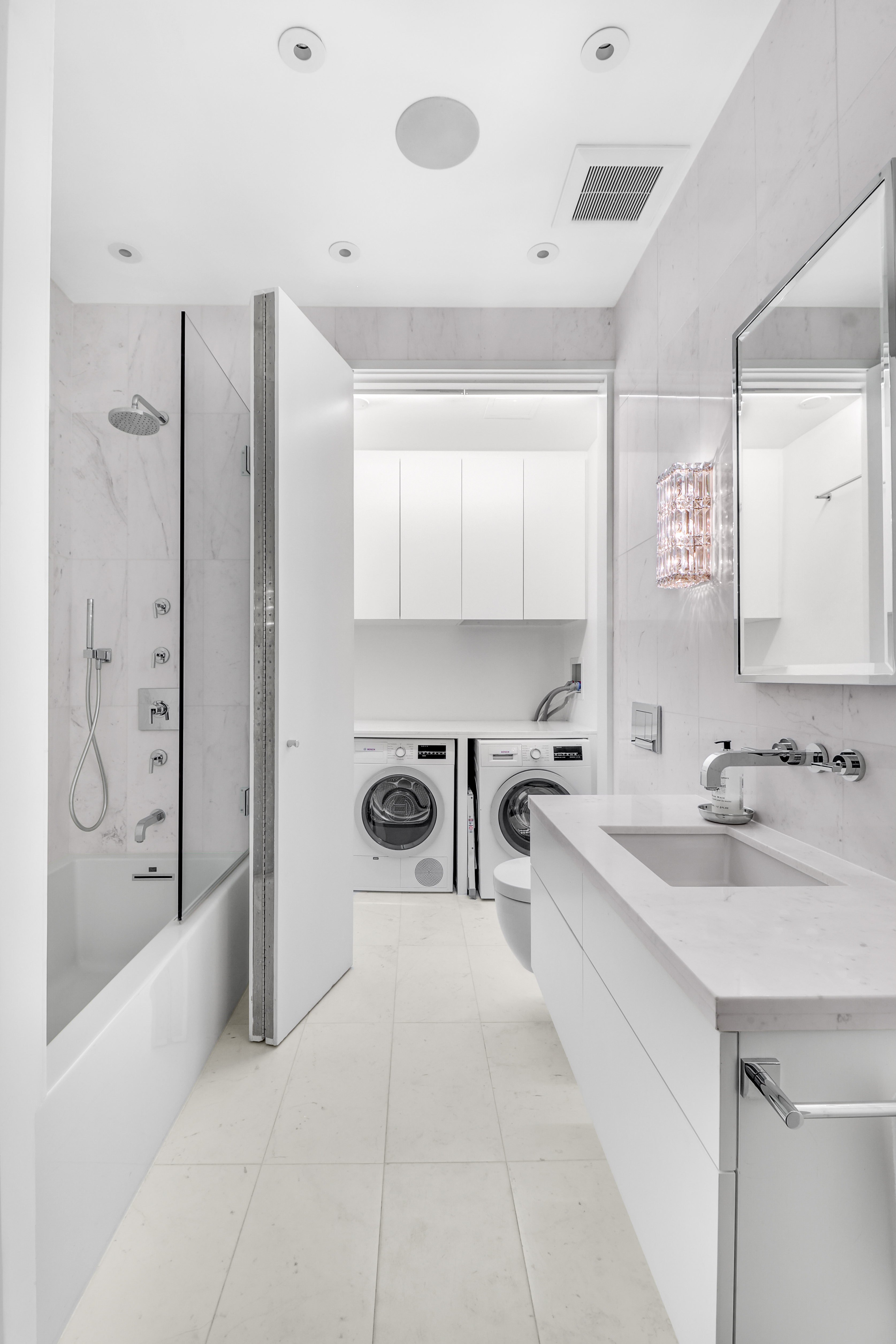 14 East 68th Street, Unit 3 Manhattan, NY 10065 - Photo 13 of 16 a spacious bathroom with a sink a mirror a bathtub and shower
