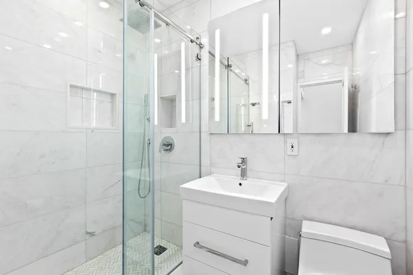a bathroom with a sink a toilet and shower