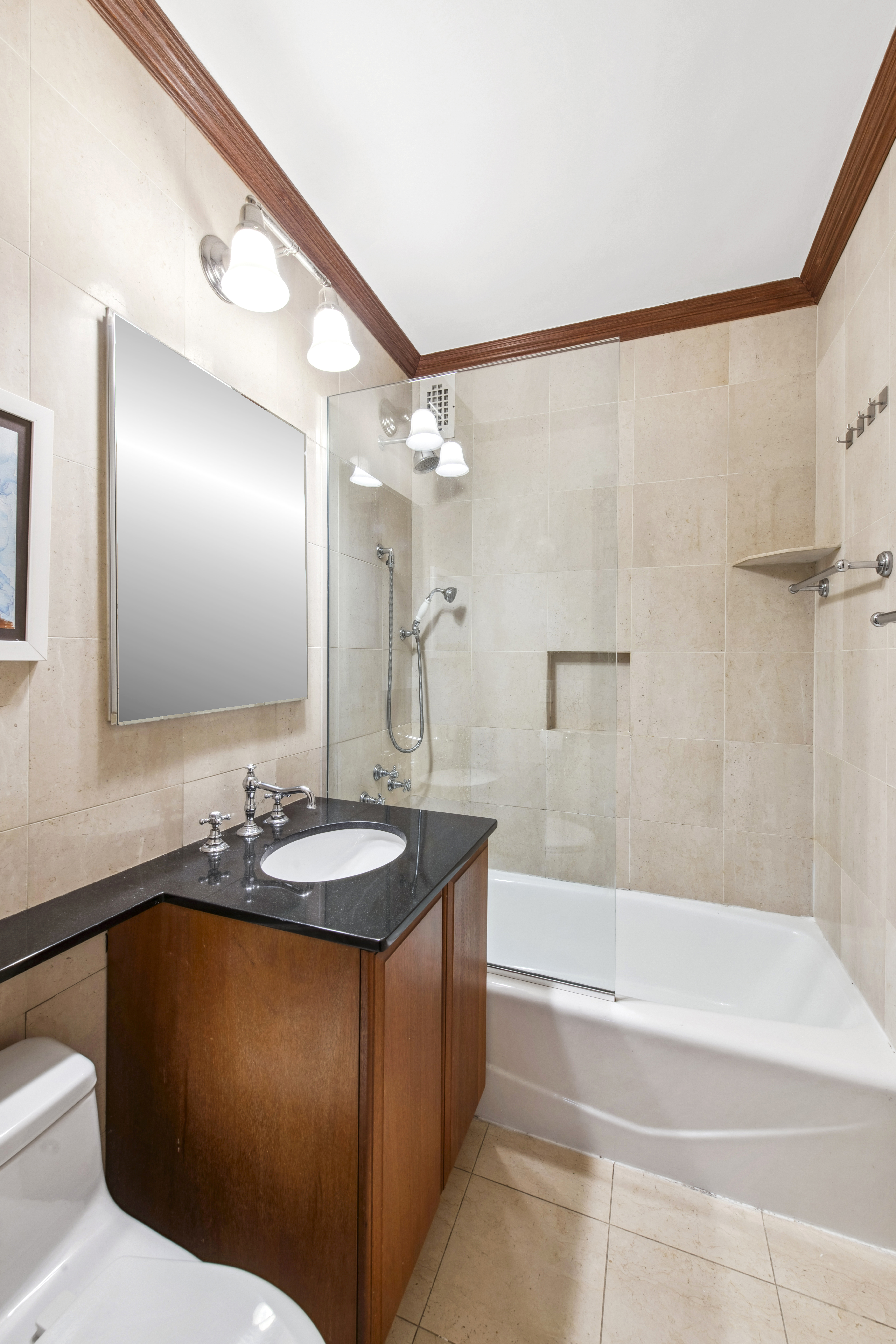 155 West 68th Street, Unit 404 Manhattan, NY 10023 - Photo 16 of 21 a bathroom with a granite countertop sink a mirror a bathtub and shower