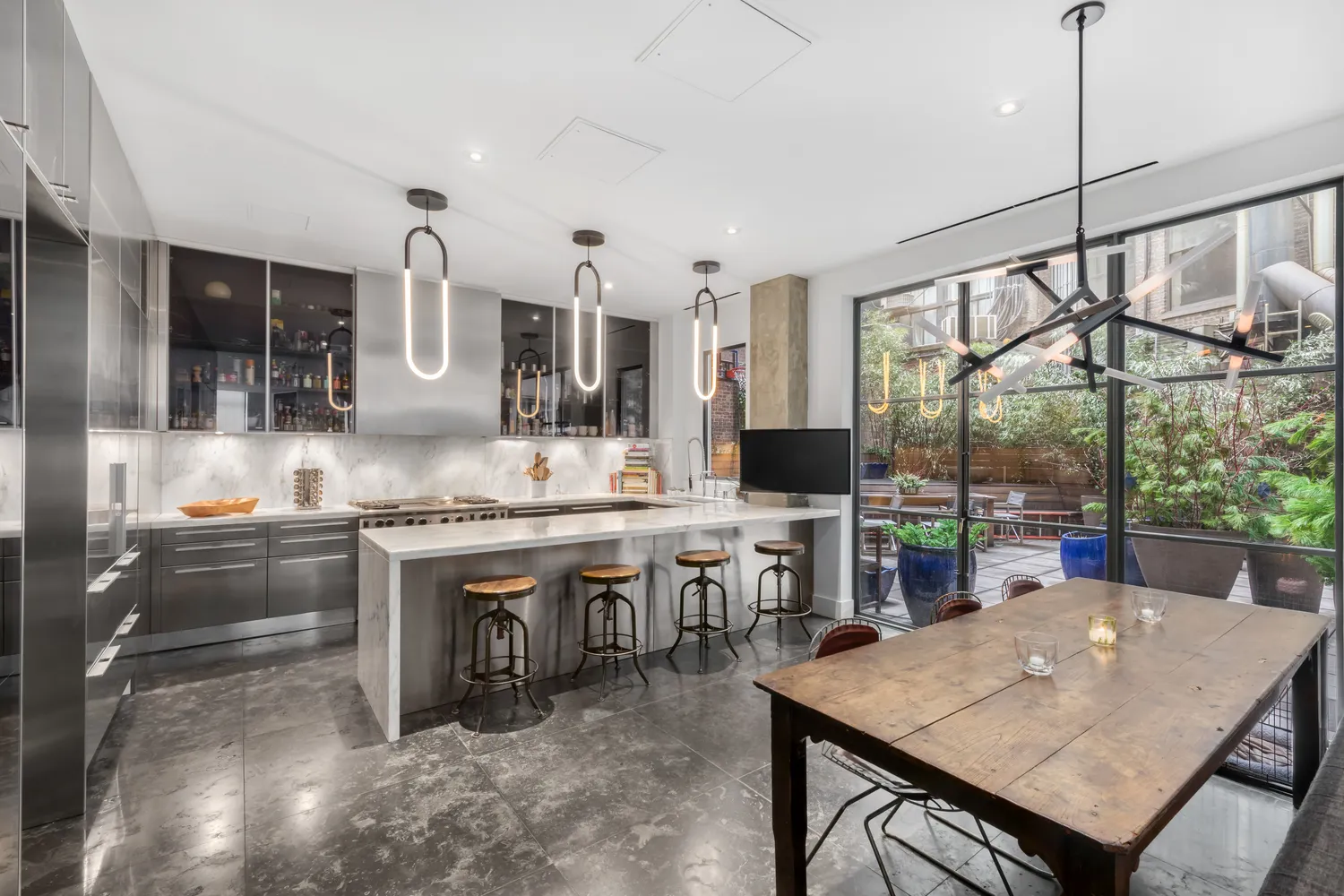 a kitchen with stainless steel appliances granite countertop a stove a kitchen island a table and chairs in it