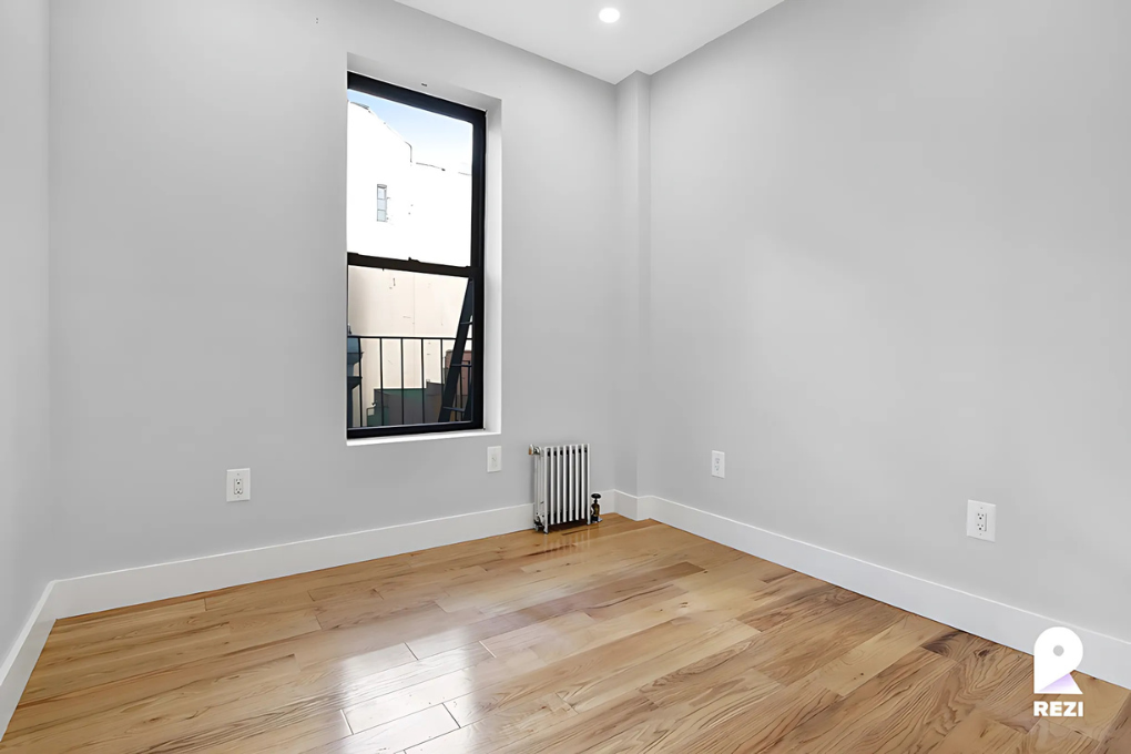 175 East 105th Street, Unit 3R Manhattan, NY 10029 - Photo 5 of 8 an empty room with wooden floor and windows