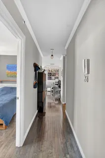 a view of a hallway with wooden floor and closet