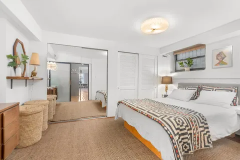 a bedroom with a bed and painting on the wall