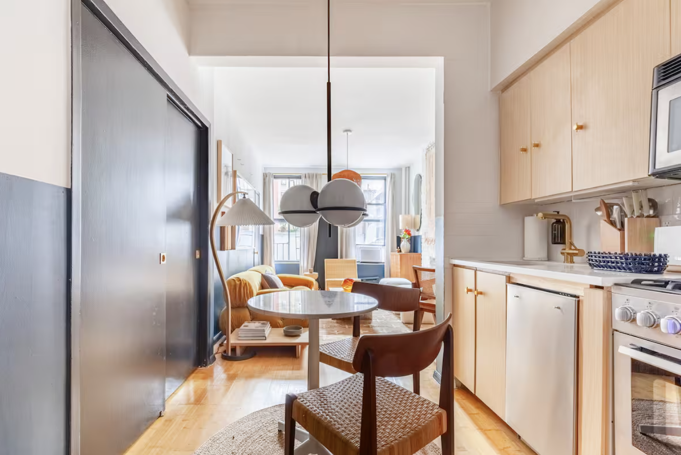 240 Mulberry Street, Unit 2 Manhattan, NY 10012 - Photo 8 of 19 a kitchen with stainless steel appliances kitchen island granite countertop dining table chairs and a refrigerator