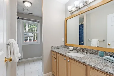 a bathroom with a granite countertop sink and a mirror