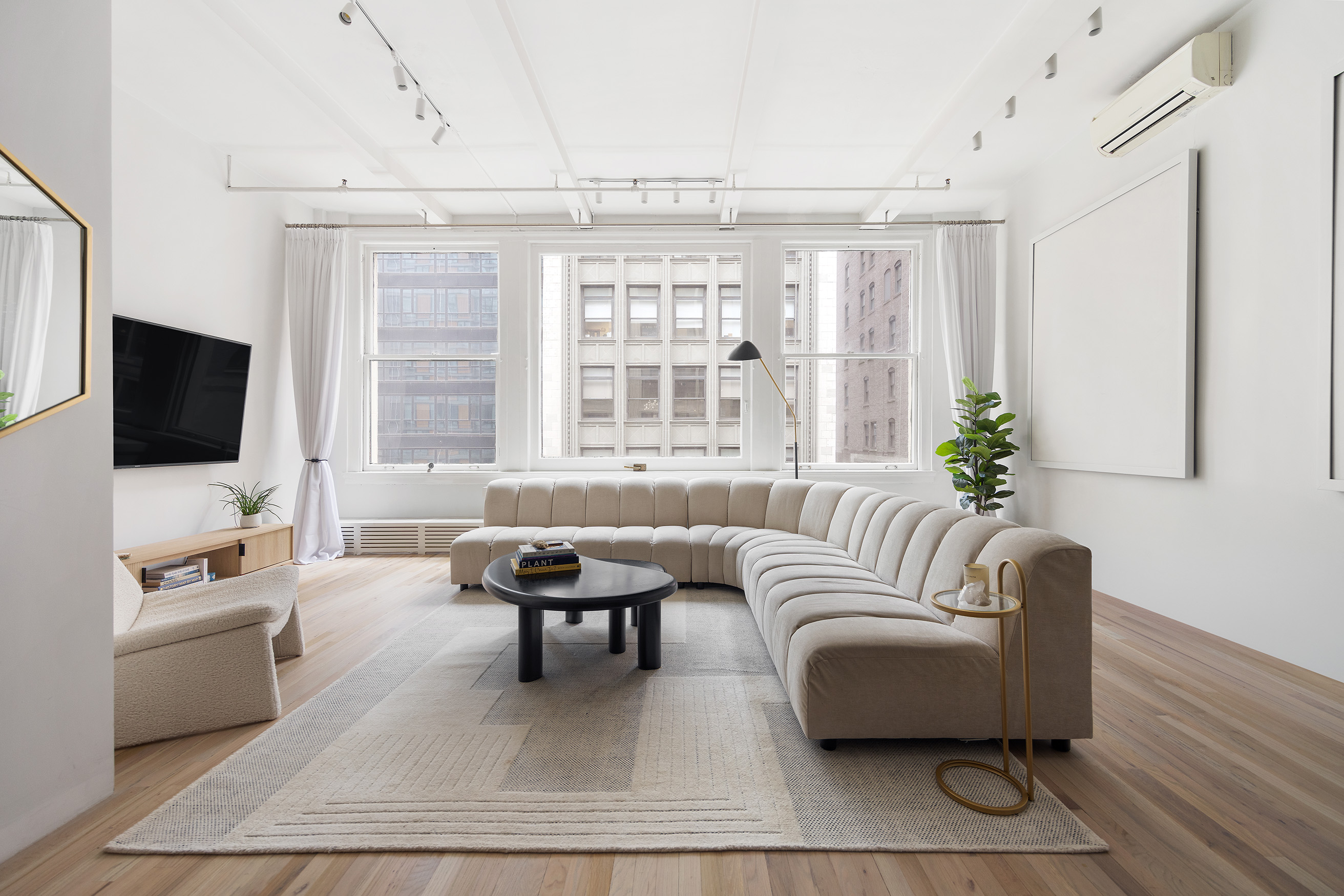 28 West 38th Street, Unit 6E Manhattan, NY 10018 - Photo 2 of 15 a living room with furniture and a flat screen tv