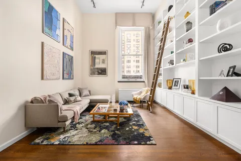 a living room with furniture and a book shelf
