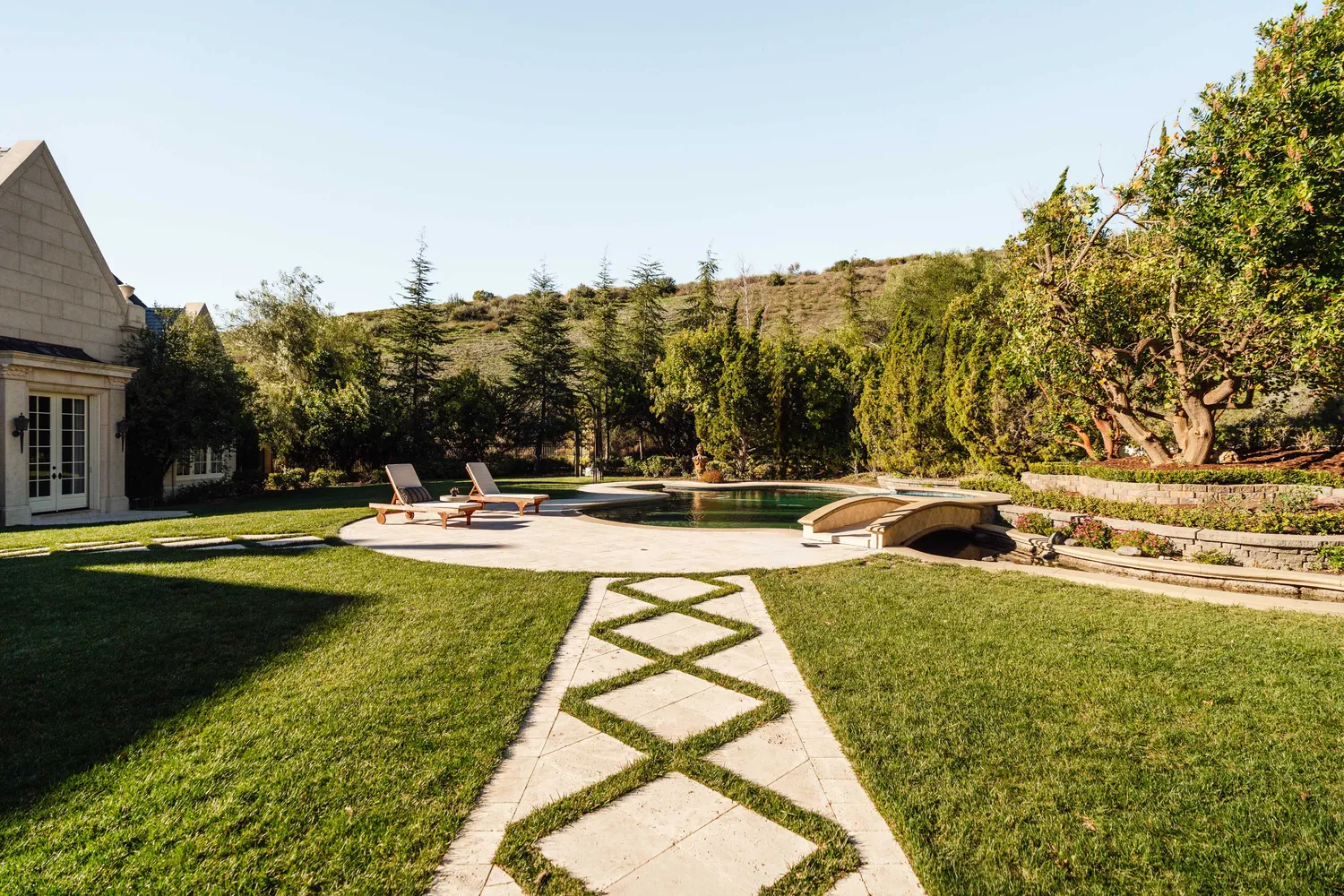 a view of swimming pool with seating area and trees