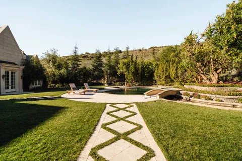 a view of swimming pool with seating area and trees