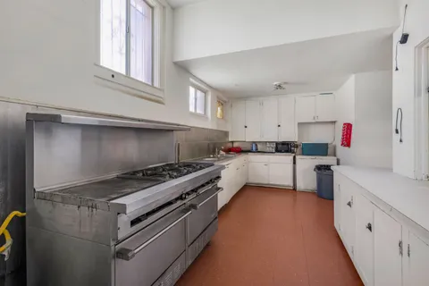 a kitchen that has a lot of cabinets in it and wooden floors