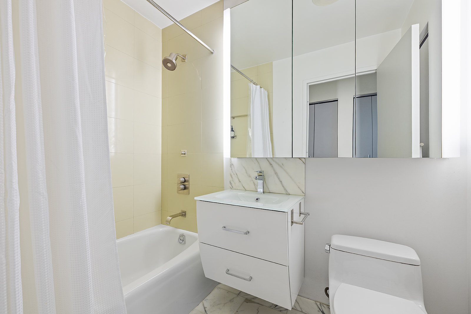 450 West 17th Street, Unit 2302 Manhattan, NY 10011 - Photo 4 of 6 a bathroom with a sink a toilet and shower
