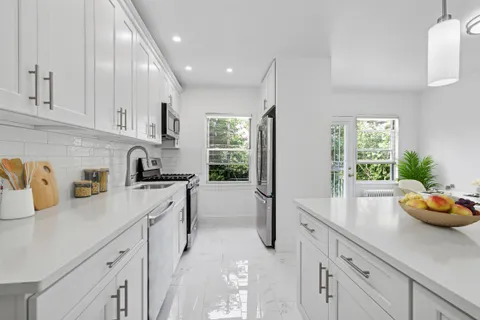 a kitchen with a sink a refrigerator and cabinets