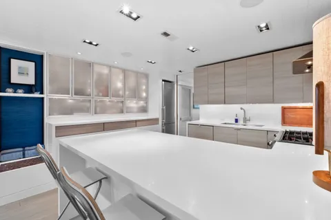 a large kitchen with stainless steel appliances a stove a sink dishwasher and a fireplace with wooden floor