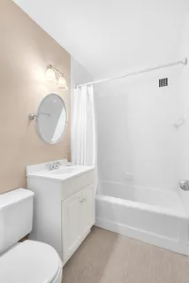 a bathroom with a toilet a sink a mirror and bathtub