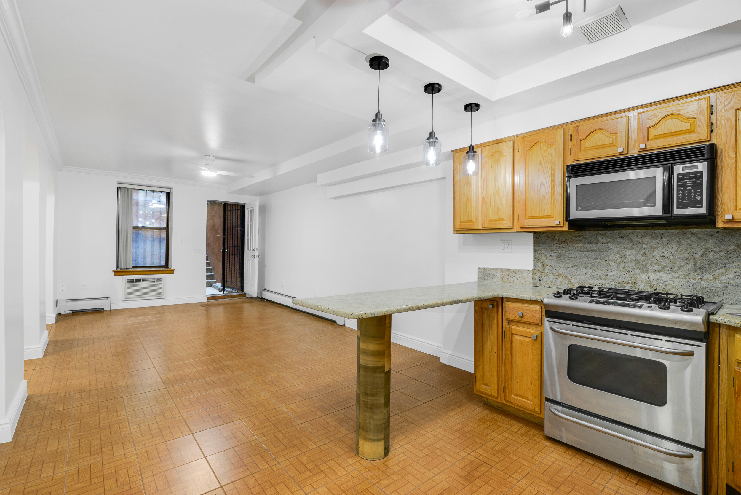 3 East 128th Street, Unit GARDEN Manhattan, NY 10035 - Photo 3 of 10 a kitchen with stainless steel appliances a stove a sink and a microwave