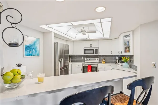 a kitchen with a table a sink cabinets and appliances