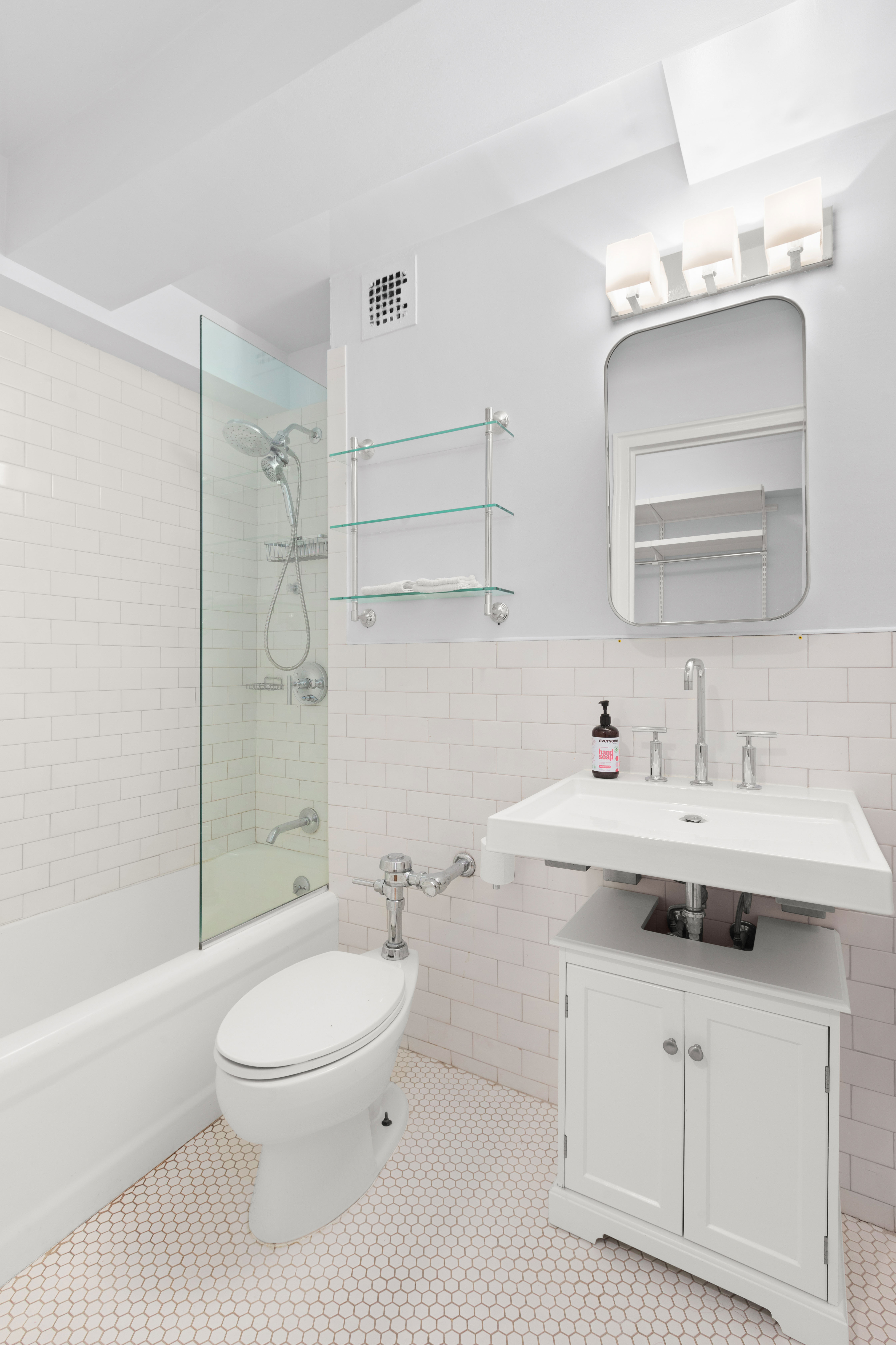 200 West 20th Street, Unit 1002 Manhattan, NY 10011 - Photo 5 of 8 a bathroom with a sink a toilet and shower