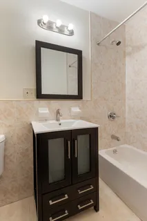 a bathroom with a sink vanity and bathtub