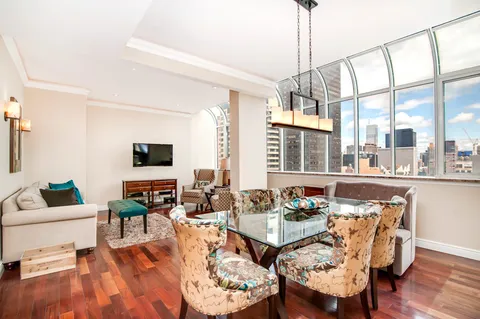 a living room with fireplace furniture and a large window