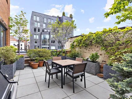a backyard of a house with a table and chairs