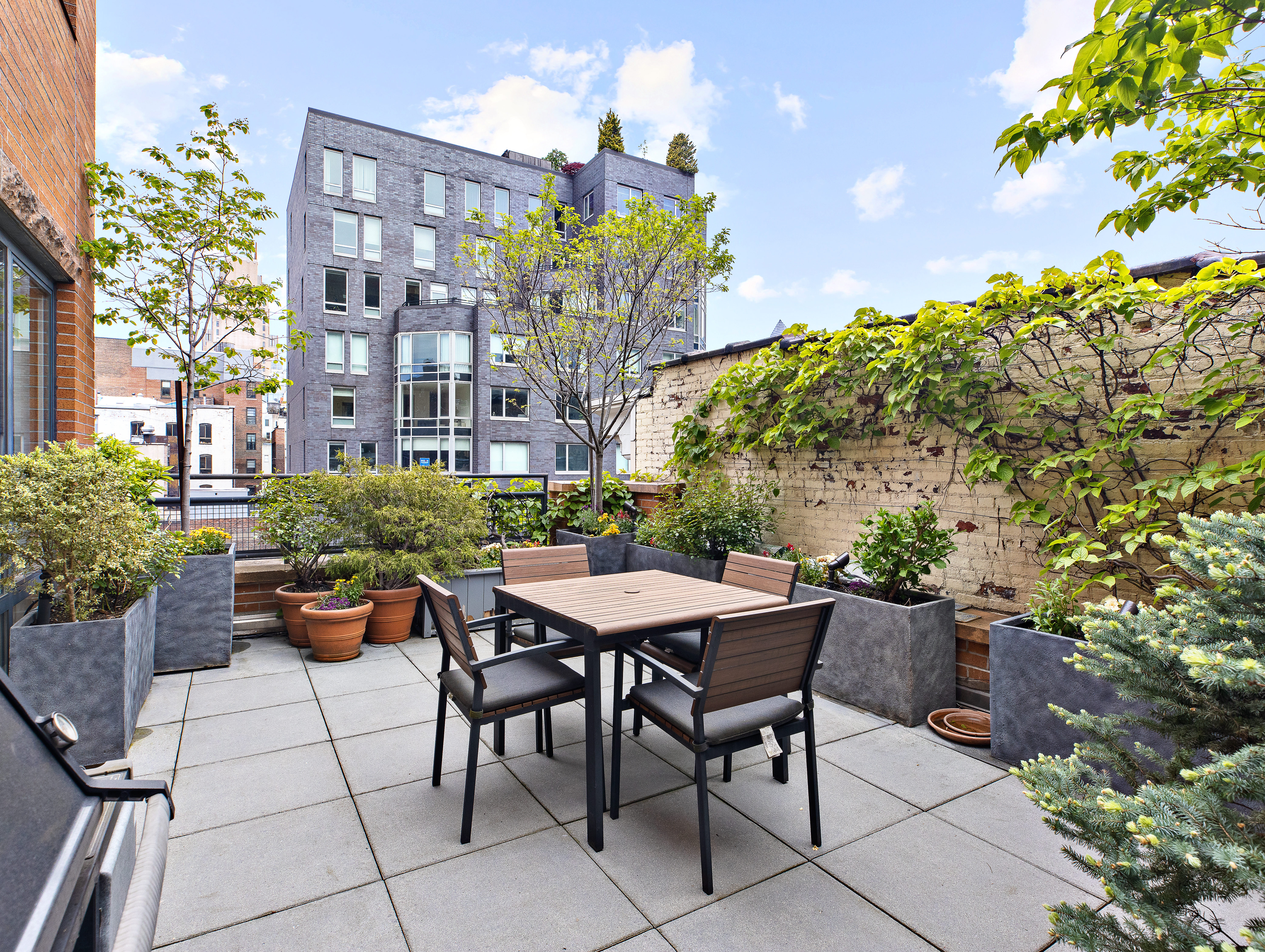 63 West 17th Street, Unit 5B Manhattan, NY 10011 - Photo 10 of 12 a backyard of a house with a table and chairs