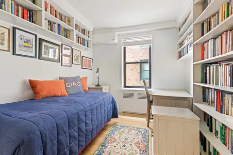 a bedroom with a bed and a book shelf