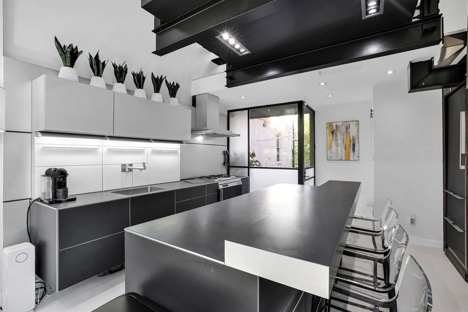 a large kitchen with stainless steel appliances a sink a table and chairs