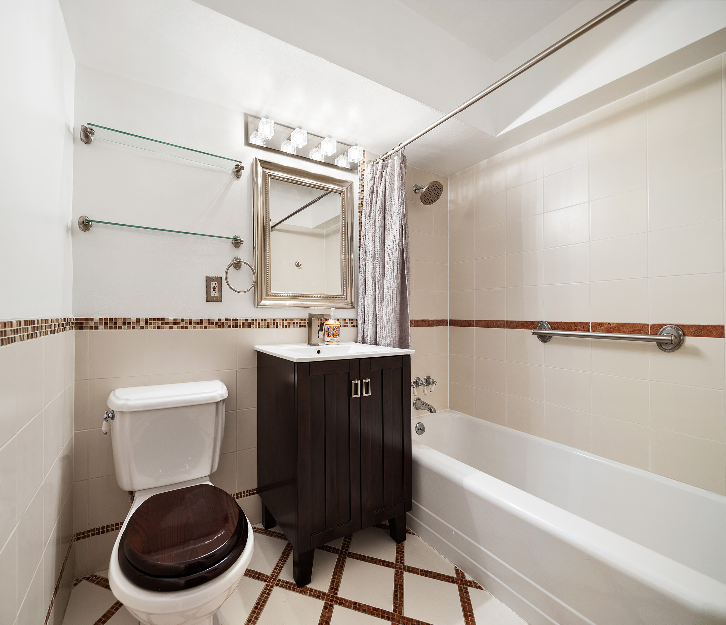 181 East 73rd Street, Unit 9G Manhattan, NY 10021 - Photo 15 of 17 a bathroom with a bathtub shower sink mirror and toilet