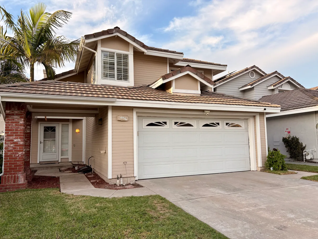 a view of a house with a yard and potted plants