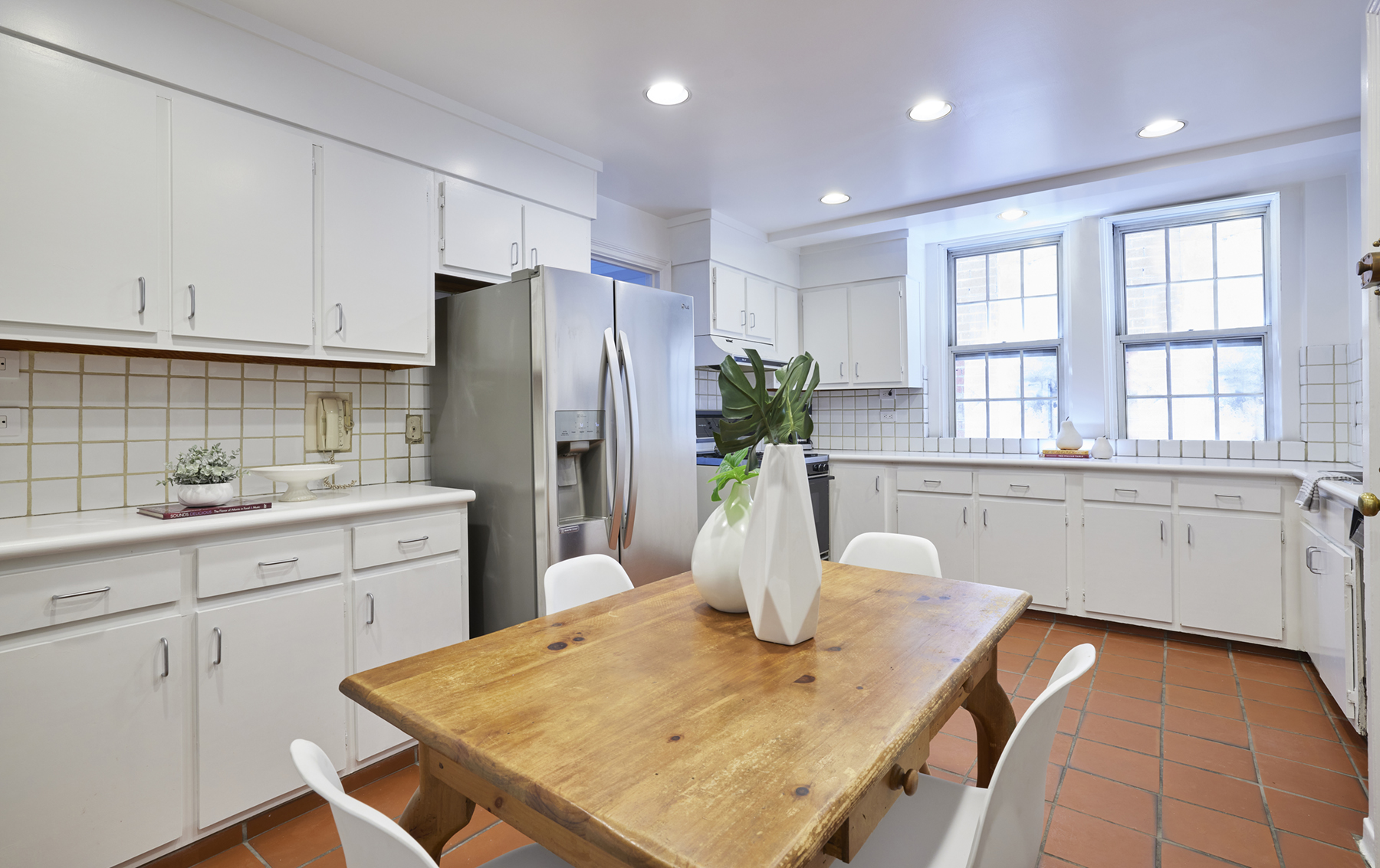 520 East 86th Street, Unit 2D Manhattan, NY 10028 - Photo 6 of 15 a kitchen with stainless steel appliances granite countertop a dining table chairs and granite counter tops