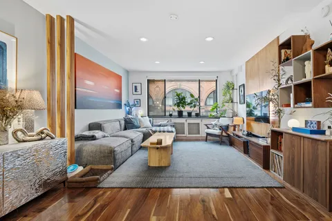 a living room with furniture and a wooden floor