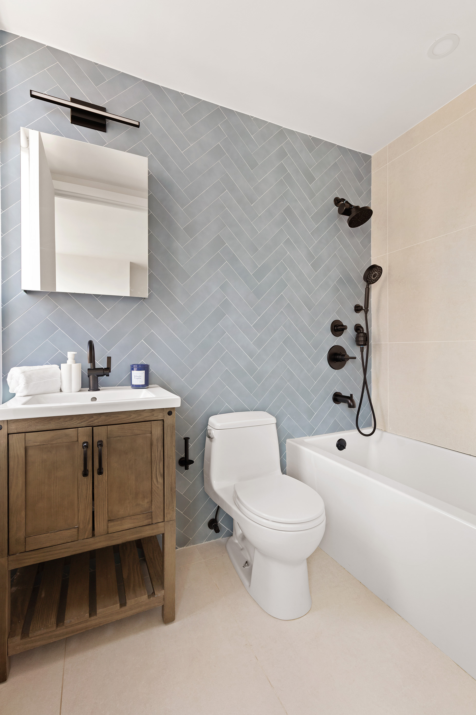 171 East 84th Street, Unit 25B/C Manhattan, NY 10028 - Photo 5 of 13 a bathroom with a toilet sink vanity tub and mirror