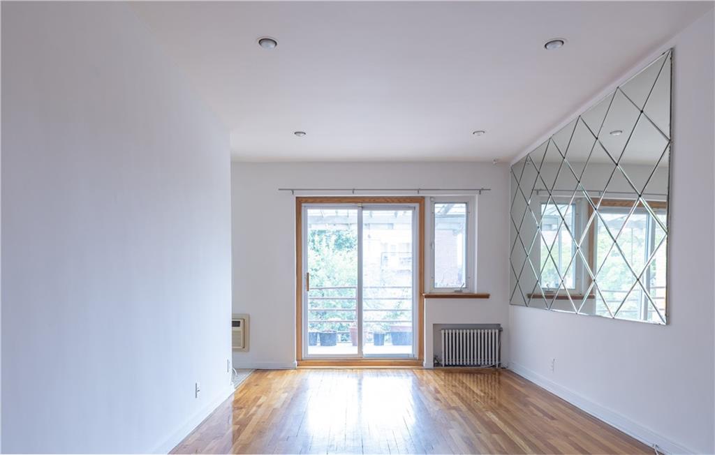 1506 Dahill Road Brooklyn, NY 11204 - Photo 5 of 13 a view of an empty room with wooden floor and a window