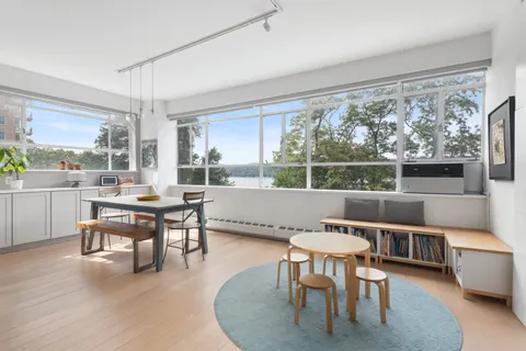 a living room with large window and furniture