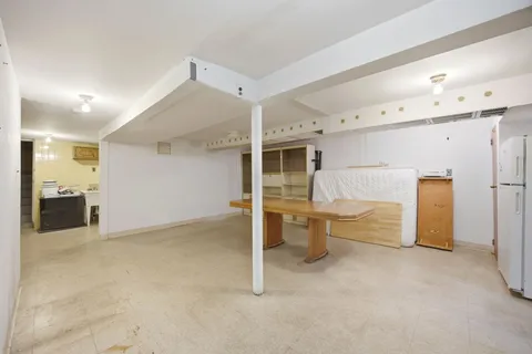 a view of a livingroom with furniture and a refrigerator