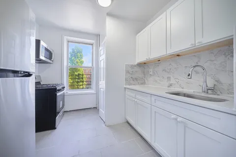 a kitchen with a sink cabinets and a refrigerator
