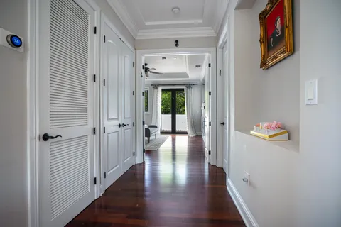 a view of a hallway with wooden floor and closet