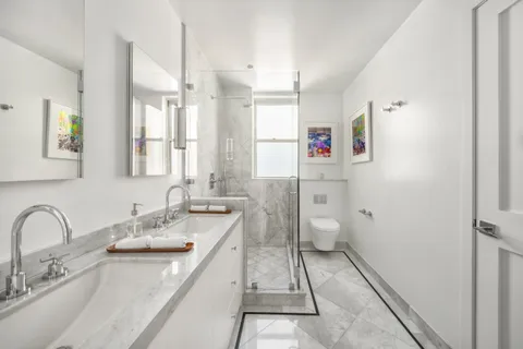 a bathroom with a granite countertop sink a toilet and a shower