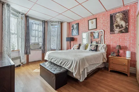 a spacious bedroom with a bed and a large window