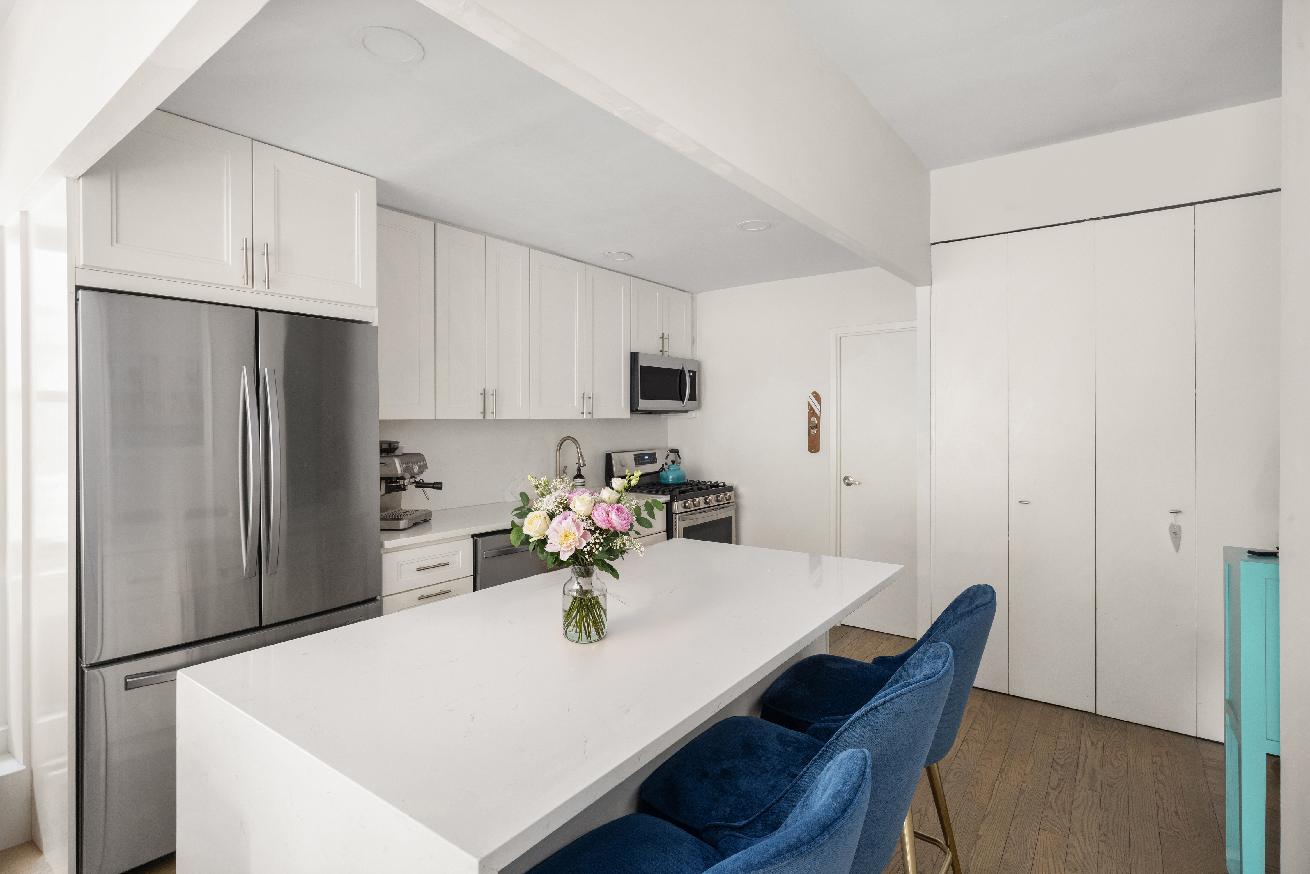 253 West 73rd Street, Unit 4N Manhattan, NY 10023 - Photo 4 of 9 a kitchen with stainless steel appliances a refrigerator and a table