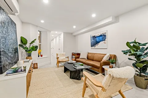 a living room with furniture potted plant and a window