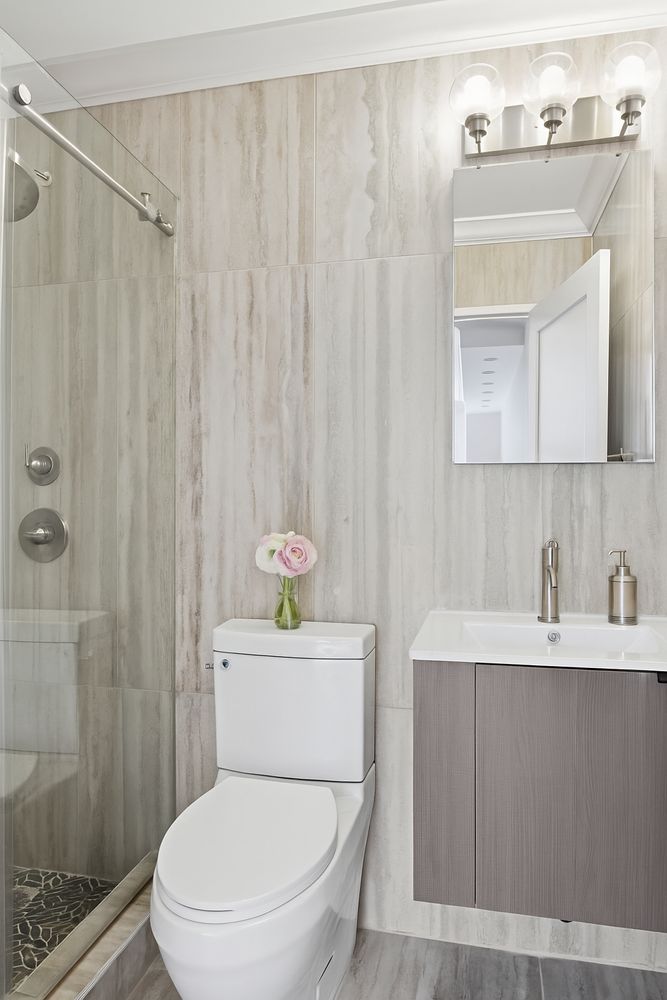 200 East 90th Street, Unit 4F Manhattan, NY 10128 - Photo 4 of 9 a bathroom with a sink a toilet and shower